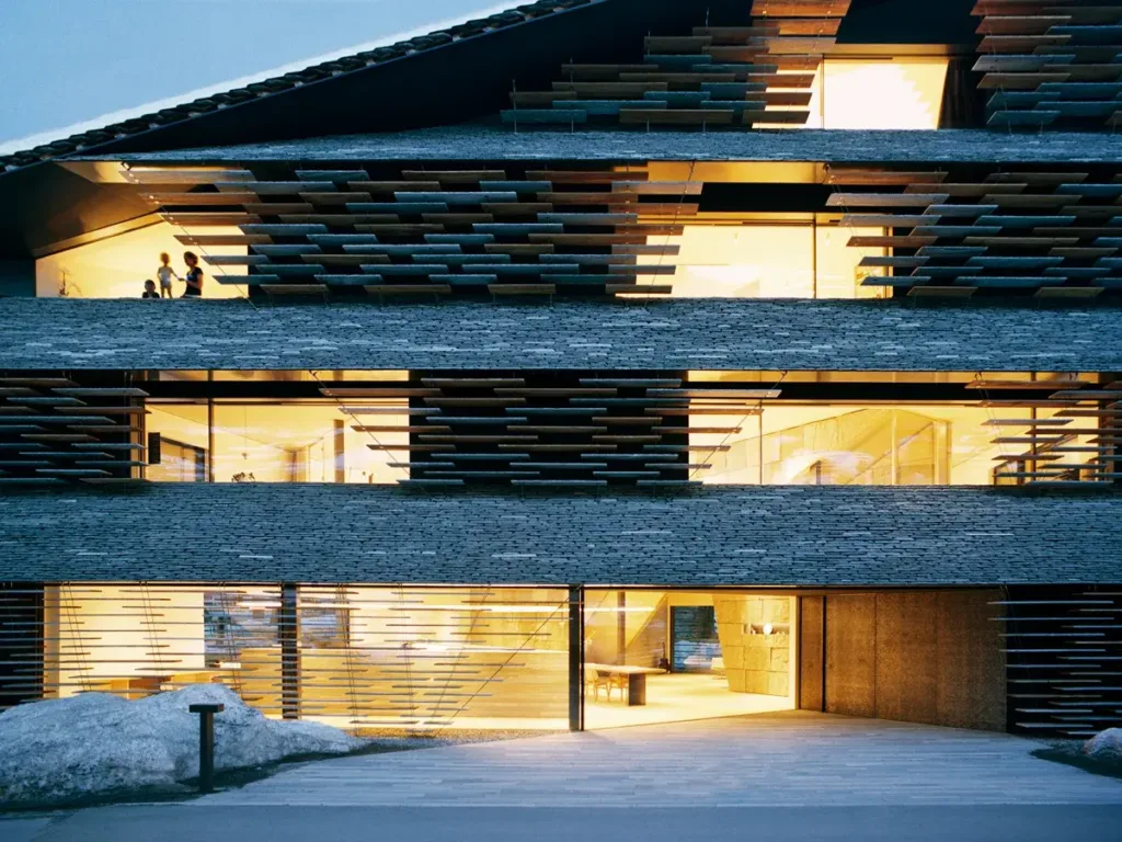 Beleuchtete Fassade des Haus Balma in Vals mit schwebenden Valser-Quarzit-Platten von Kengo Kuma